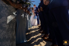 A couple’s portrait at Bank Street Beach in Harwich, MA, beautifully framed by their loved ones, symbolizing two worlds coming together at the center.